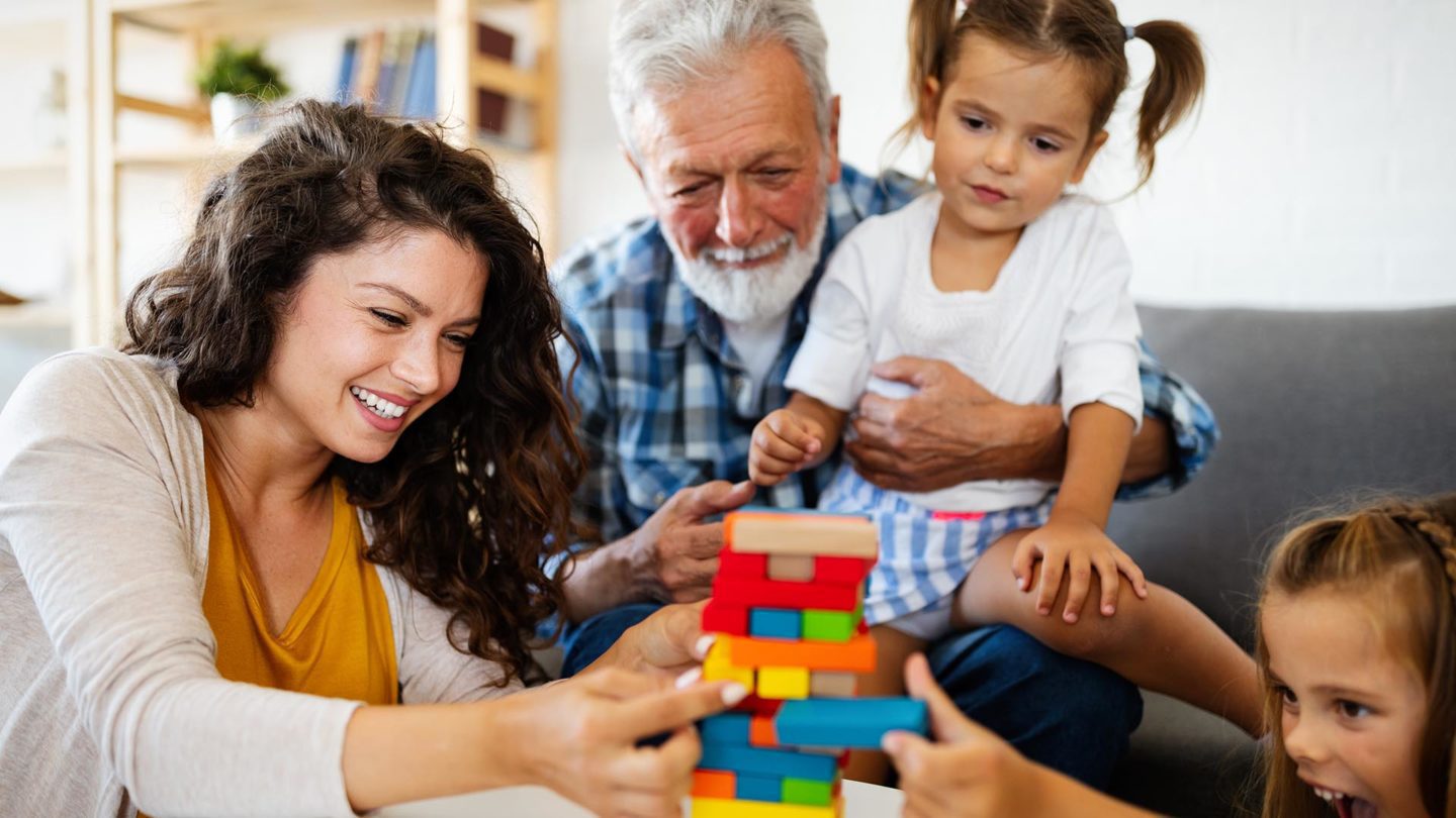 A group of people sitting around playing with blocks.