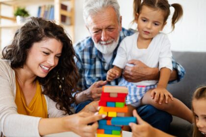 A group of people sitting around playing with blocks.