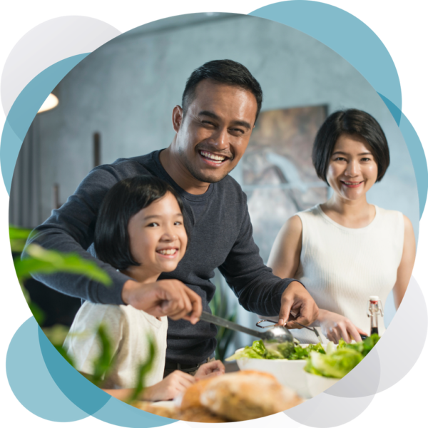 A man and two women are cutting vegetables.