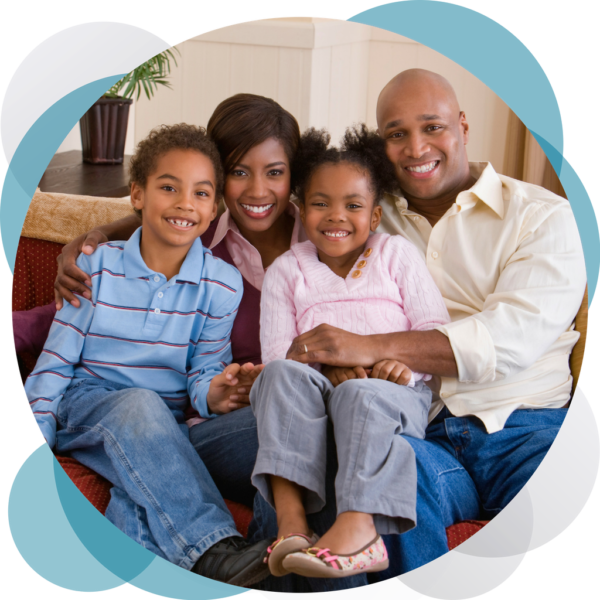 A family sitting on the couch together.