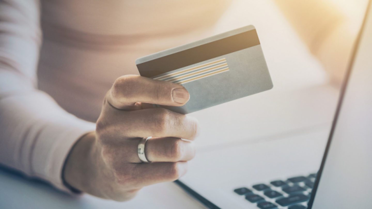 A person holding a credit card in their hand.